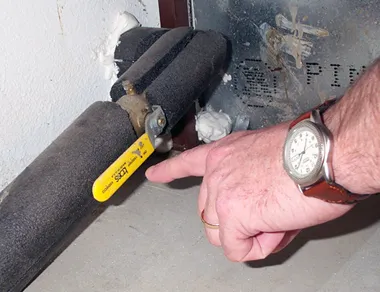 Hand pointing to example of emergency water shut-off